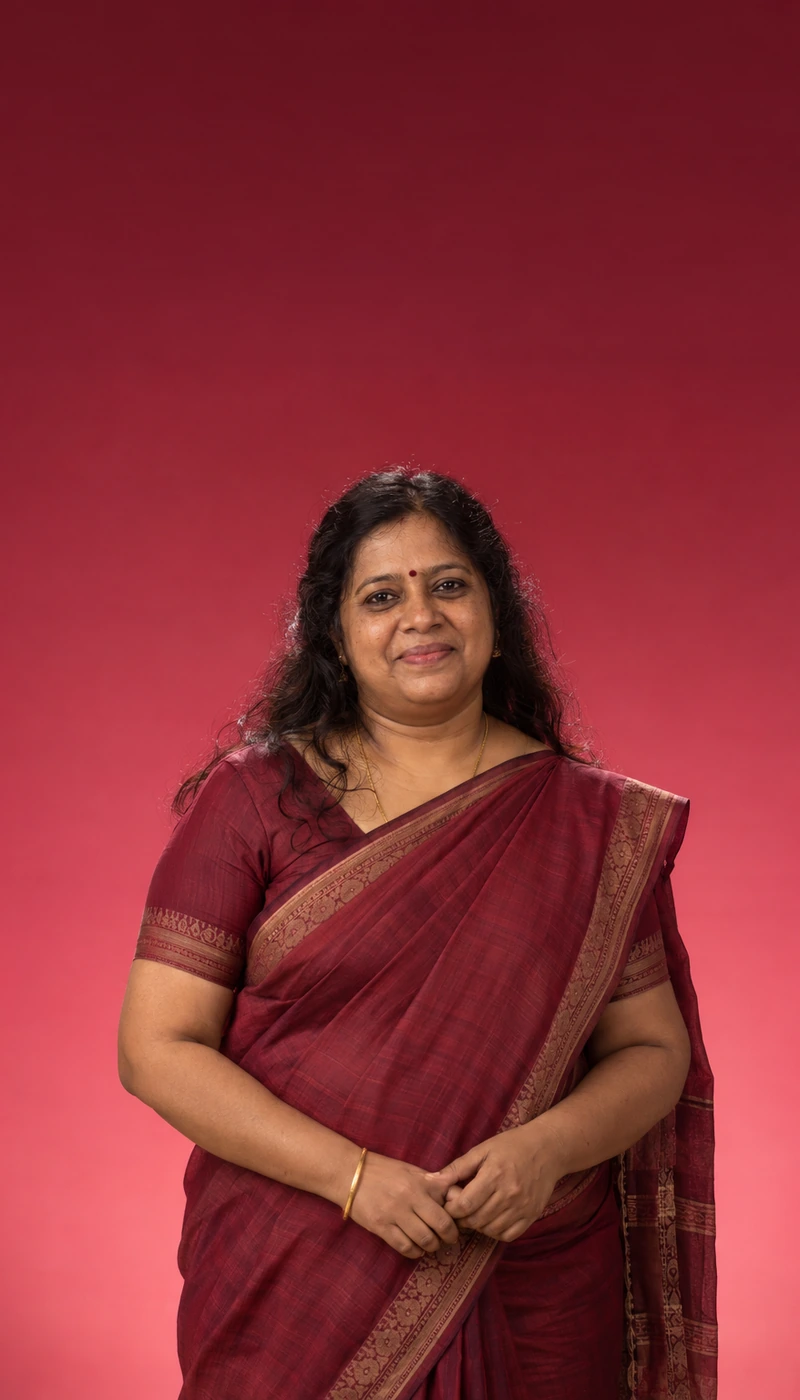 Woman in a maroon saree smiling gently