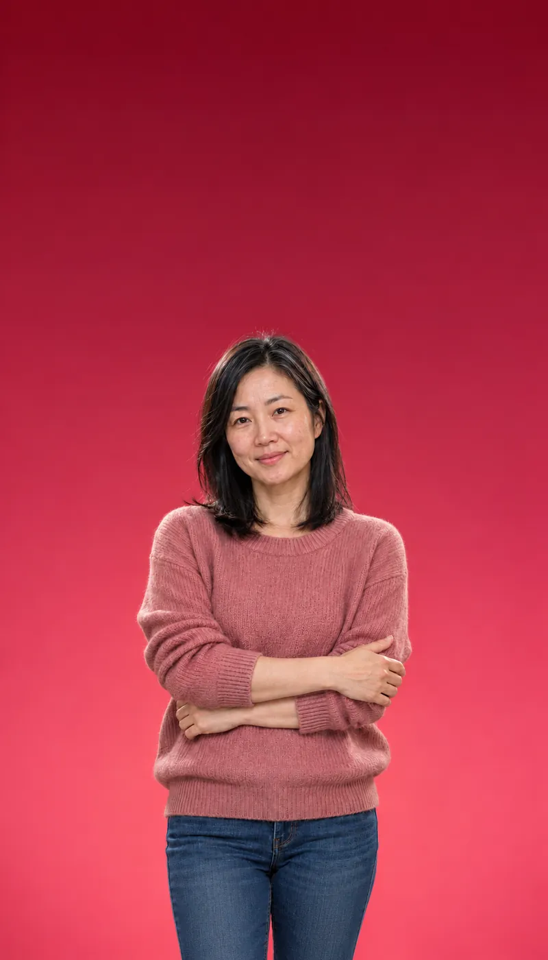 Woman in a dusty rose sweater with arms loosely crossed